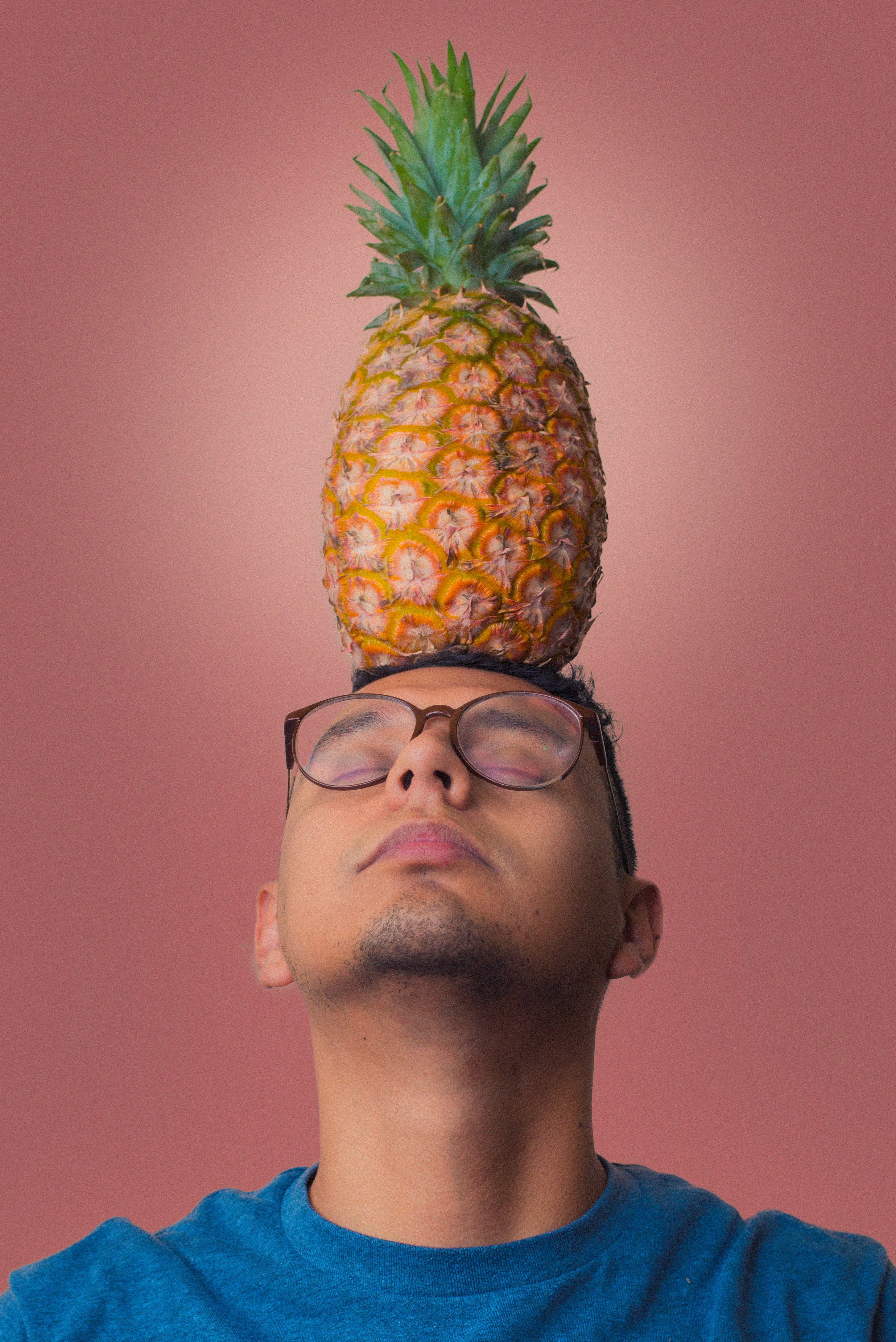 man in black framed eyeglasses and pineapple fruit